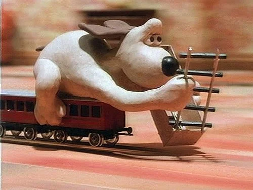 Gromit placing rails in front of a moving train